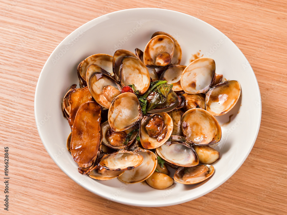 Fototapeta premium Stir-frying Ginger and clams at high heat to bring forth the savory aroma with sesame oil in recipe