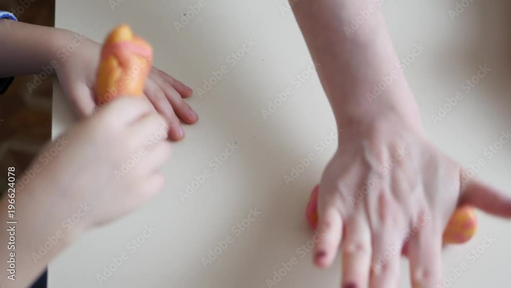 Children's creativity. Children's hands form figures from the dough on the table. Cute children's plasticine figurines on the table.
