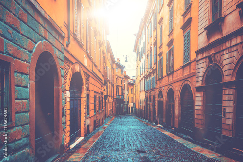 beautiful and ancient buildings in a street with warm sunlight in the middle