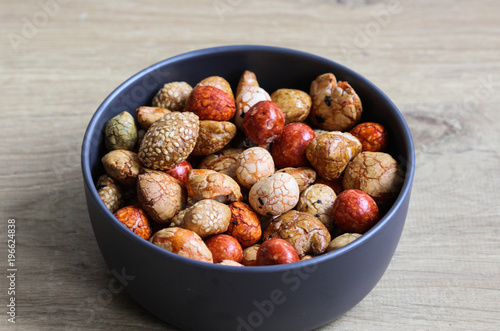 Bowl with Japanese cocktail nuts on wooden background