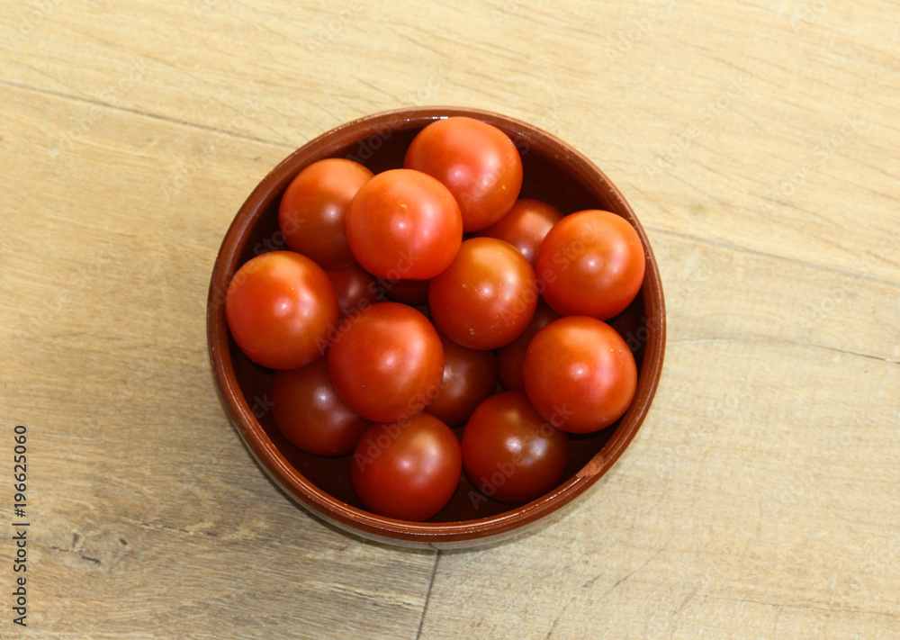 Cherry tomatoes on wooden background in kitchen Cherry tomatoes on wooden background in kitchen