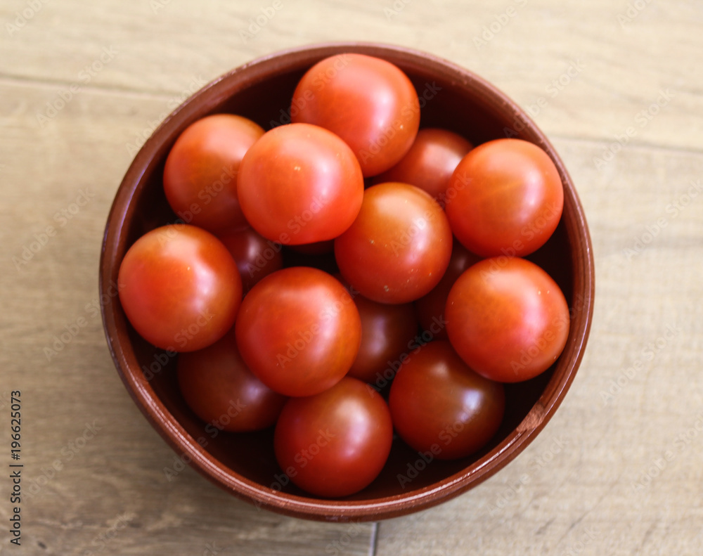 Cherry tomatoes on wooden background in kitchen Cherry tomatoes on wooden background in kitchen