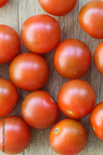 Cherry tomatoes on wooden background in kitchen