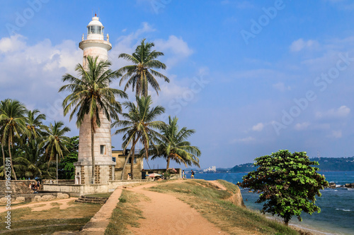 Leuchtturm in Galle, Sri Lanka, mit Palmen und blauen Himmel