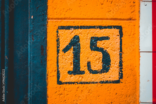 orange painted number 15 door sign