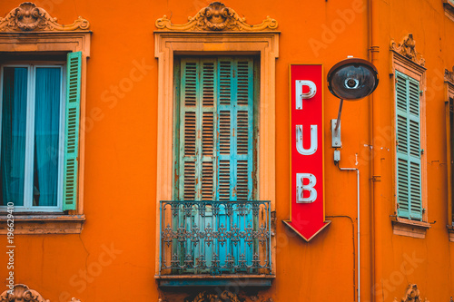 Canvas Print red pub sign in white letters on a orange facade