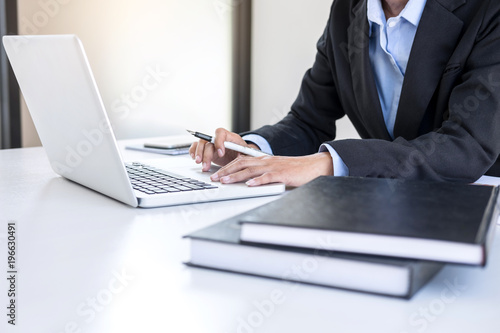 Intelligent female businesswoman working on laptop while analysis business strategy and sale performance contract on workplace