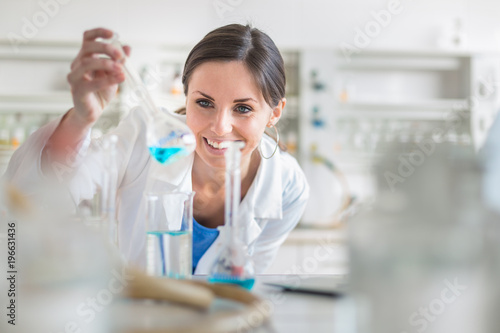 Young  female researcher carrying out experiments in a lab  shallow DOF  color toned image 