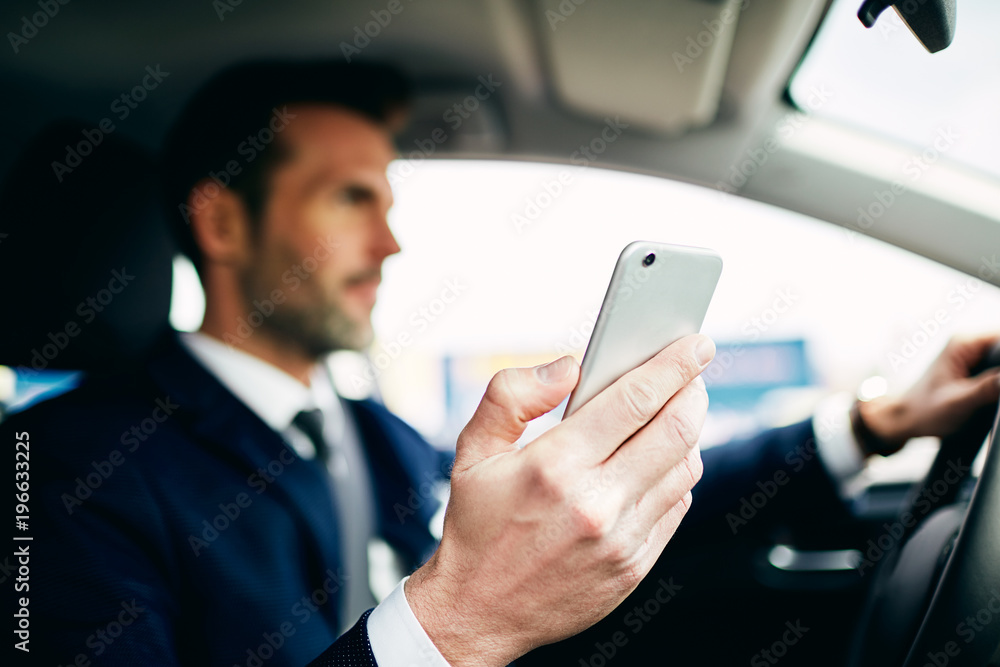 Close up of man using phone while driving car