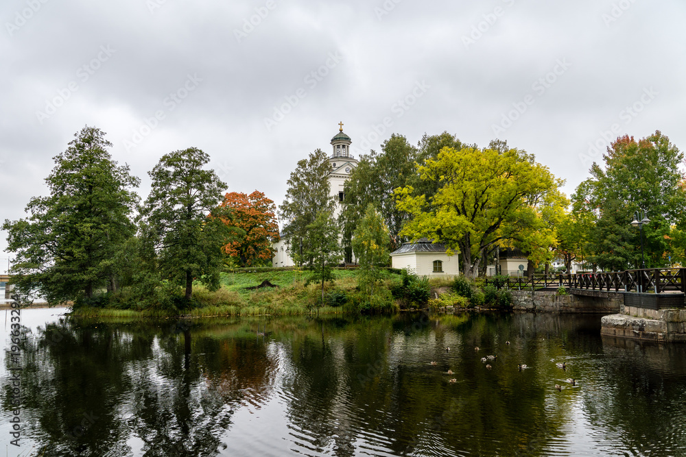Autumn view of a white church located by a river