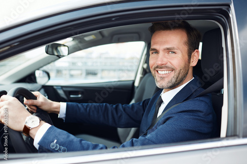 Portrait of smiling businessman driving car © baranq
