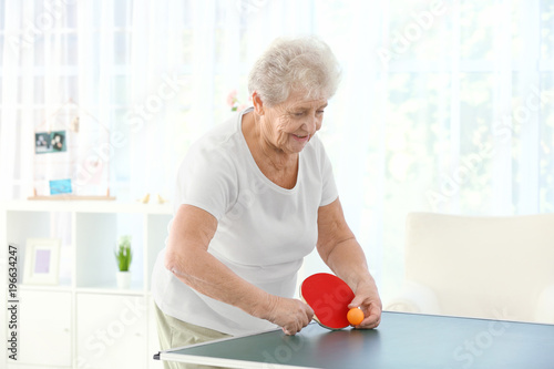Senior woman playing table ...