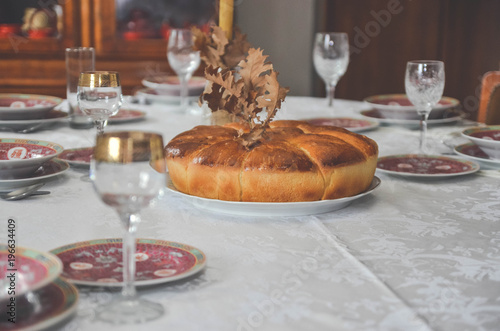 Christmas bread, candle, tree and glasses for wine.Orthodox Christmas on the table. photo