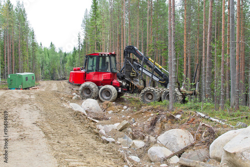 Harvesting machine near the forest path waiting before next work. Wood industry in Russia