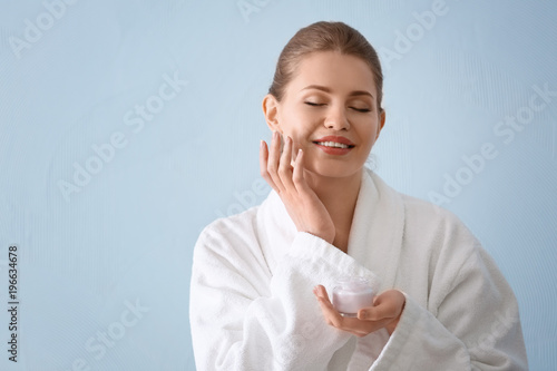 Young woman applying cream ...