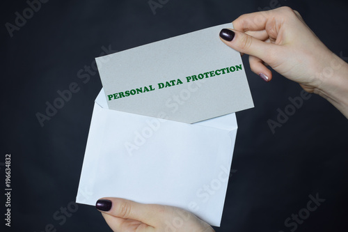 In the hands of a businessman an envelope with the inscription:PERSONAL DATA PROTECTION