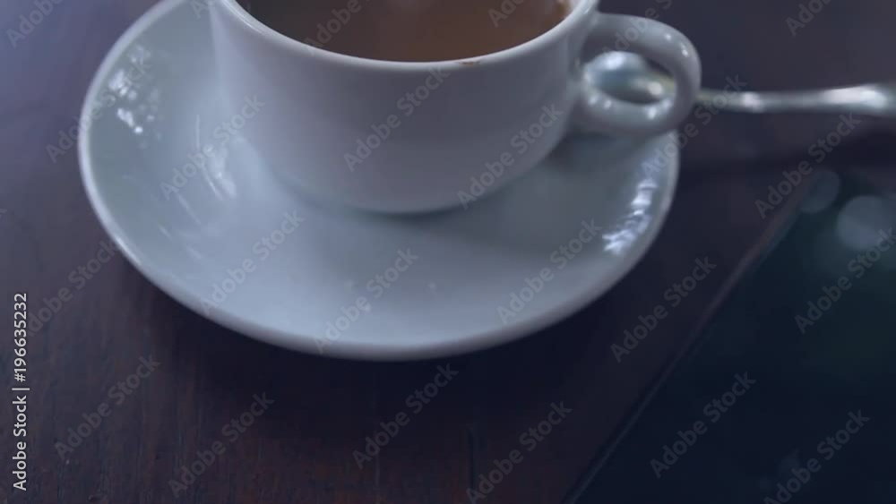 White with coffee is on the desk near a black phone with a blurry reflection on the screen. slow motion, 1920x1080, full hd White with coffee is on the desk near a black phone with a blurry reflection on the screen. slow motion, 1920x1080, full hd