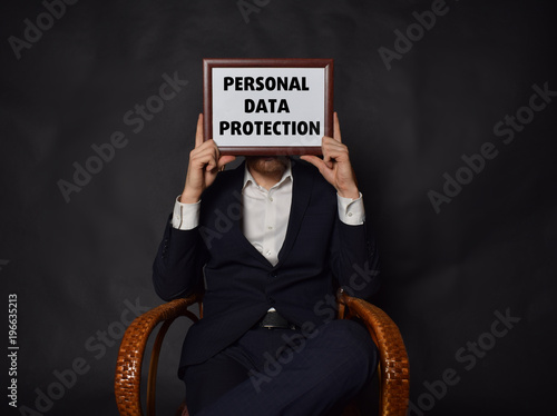 In the hands of a businessman a frame with the inscription:PERSONAL DATA PROTECTION