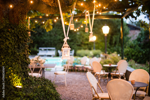 villa garden with large magnolia tree with many lanterns hanging from its branches