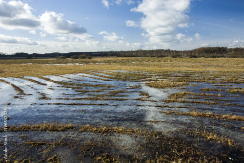 Flooded large meadow and clouds in the sky