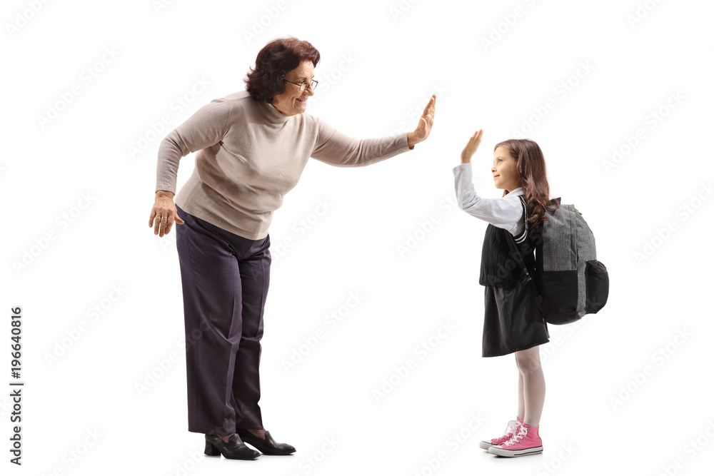 Elderly woman high-fiving a schoolgirl Elderly woman high-fiving a schoolgirl