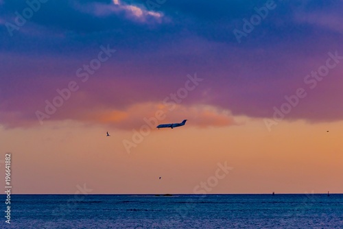 brilliant sunset over the port of Aruba in the Caribbean sea with ships and planes landing