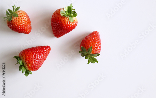 Food background .Closeup on a freshly organic red ripe strawberries lying on a white background.Summer ripe berries.Delicious fruit. Space for text in corner .Blurred background.