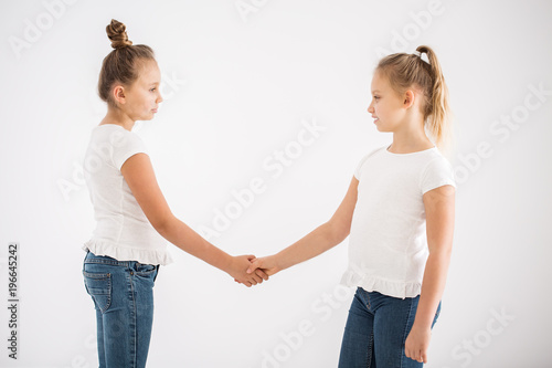 Blonde girls shaking hands