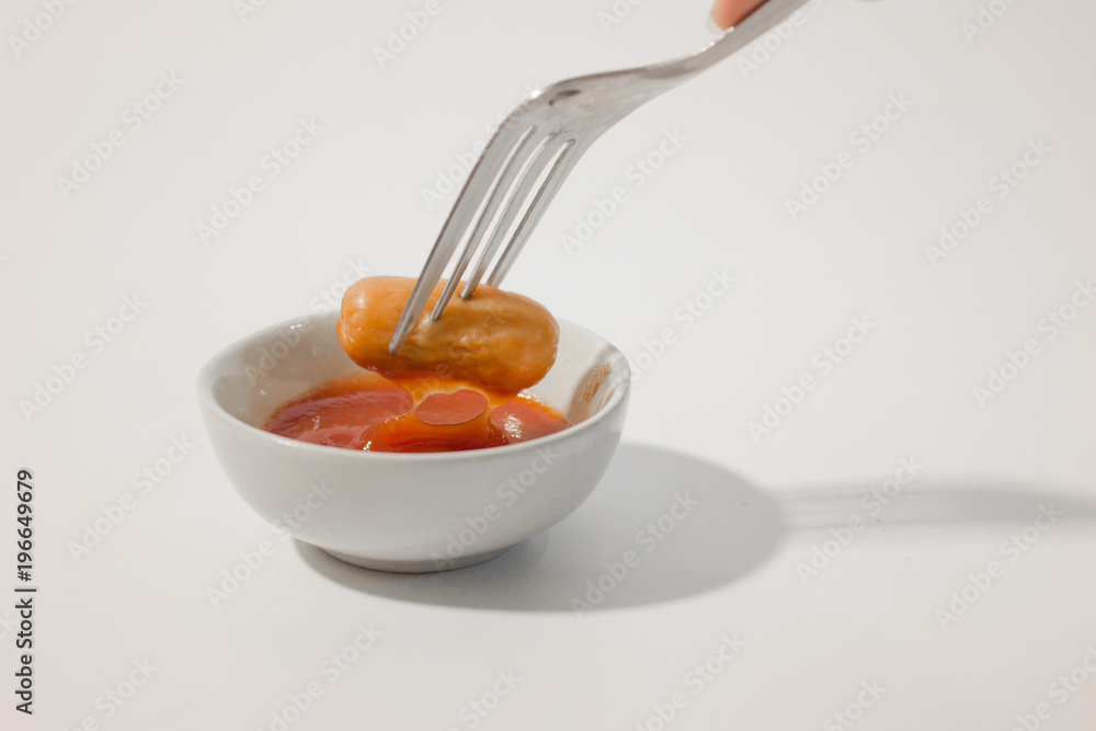 sausage dip a ketchup on white background. sausage dip a ketchup on white background.
