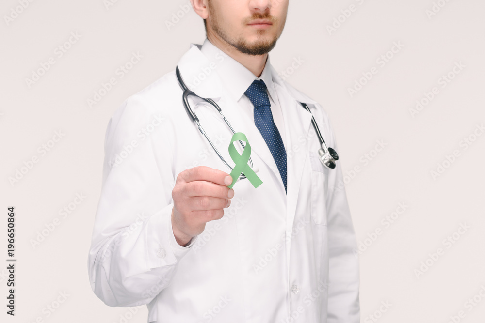 cropped shot of doctor with stethoscope showing green ribbon isolated on white, world health day concept cropped shot of doctor with stethoscope showing green ribbon isolated on white, world health day concept