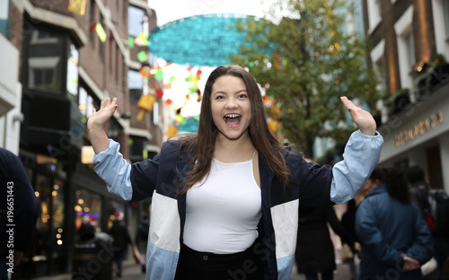 Beautiful Asian Woman Portrait Outdoors with Brown Hair Smiling With The Hands Up