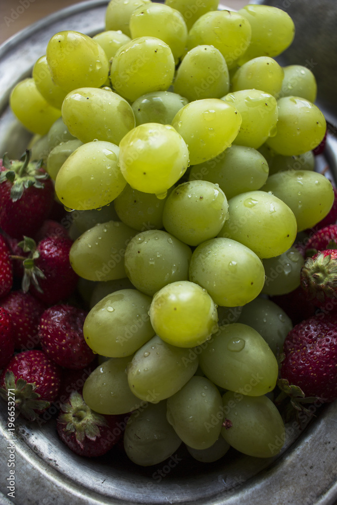 photo of fresh, green, ripe grapes and fragrant strawberries