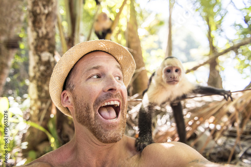Photography men tourist makes selfie self portrait with monkey