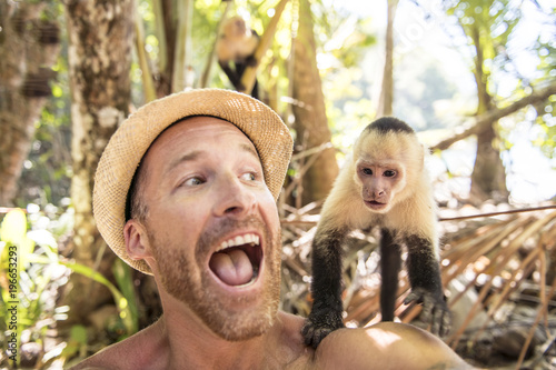 Photography men tourist makes selfie self portrait with monkey