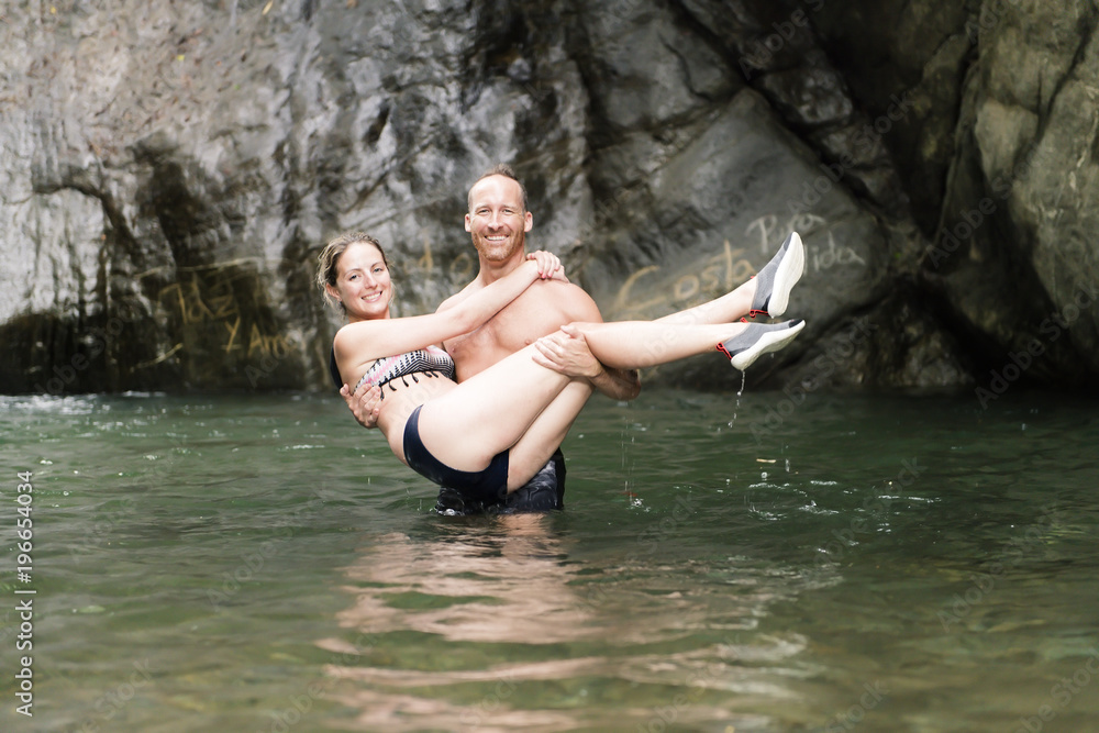 Attractive couple under jungle waterfall Attractive couple under jungle waterfall