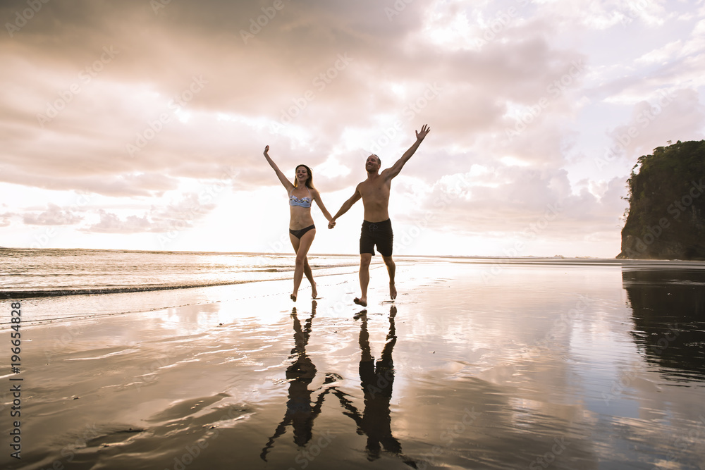 Fototapeta premium Couple in love having romantic tender moments at sunset on the beach