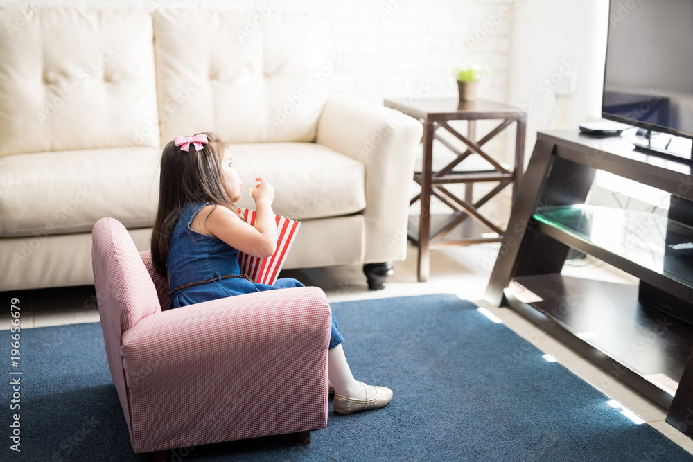 Cute girl watching a movie on tv at home Cute girl watching a movie on tv at home