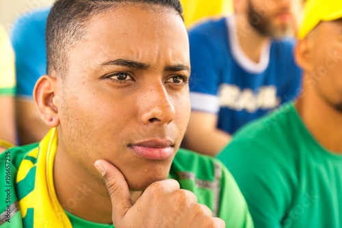 Friends from Brazil watching football match. Worried man.