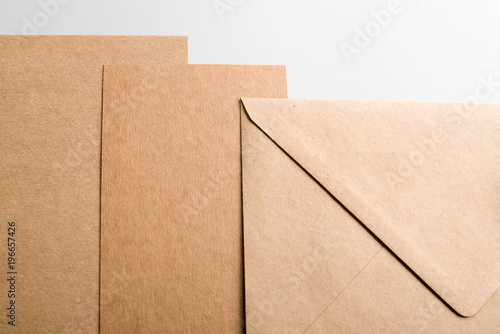 Top view of cardboard and brown envelope on gray background. Mockup.