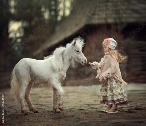 a little girl with a mini horse