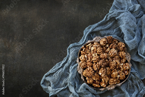 Close-up of a bowl with walnuts on a vintage wooden background. Top view, background. photo