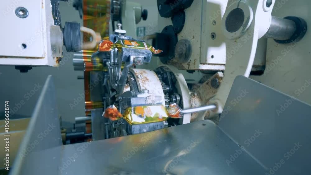 Factory machine is wrapping chocolate sweets up Factory machine is wrapping chocolate sweets up