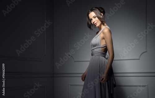 Quadro em tela Beautiful female model wear evening dress and posing in stylish room
