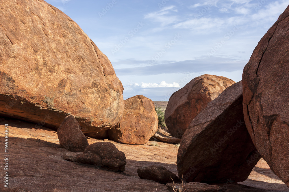 Devils Marbles are huge granite boulders scattered across a wide, shallow valley, 100 kilometers south of Tennant Creek in the Northern Territory, Australia.