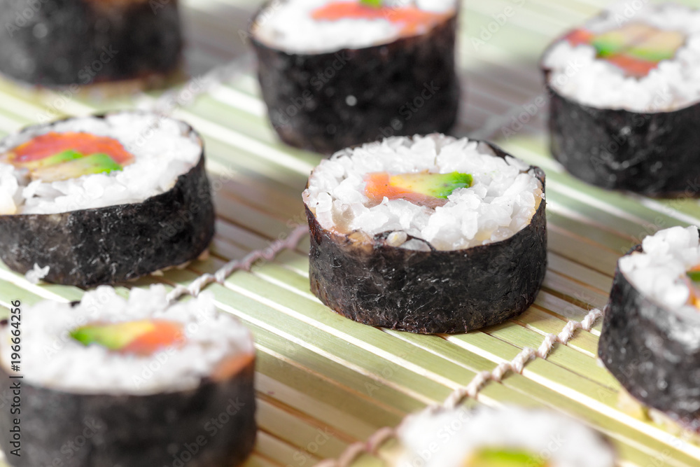 Sushi rolls on bamboo mat. Concept design. Japanese cuisine. Sushi rolls on bamboo mat. Concept design. Japanese cuisine.