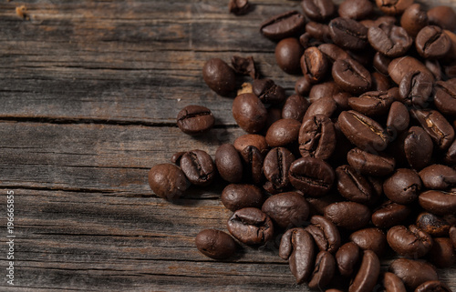 Spilled grains of roasted coffee on old raw boards