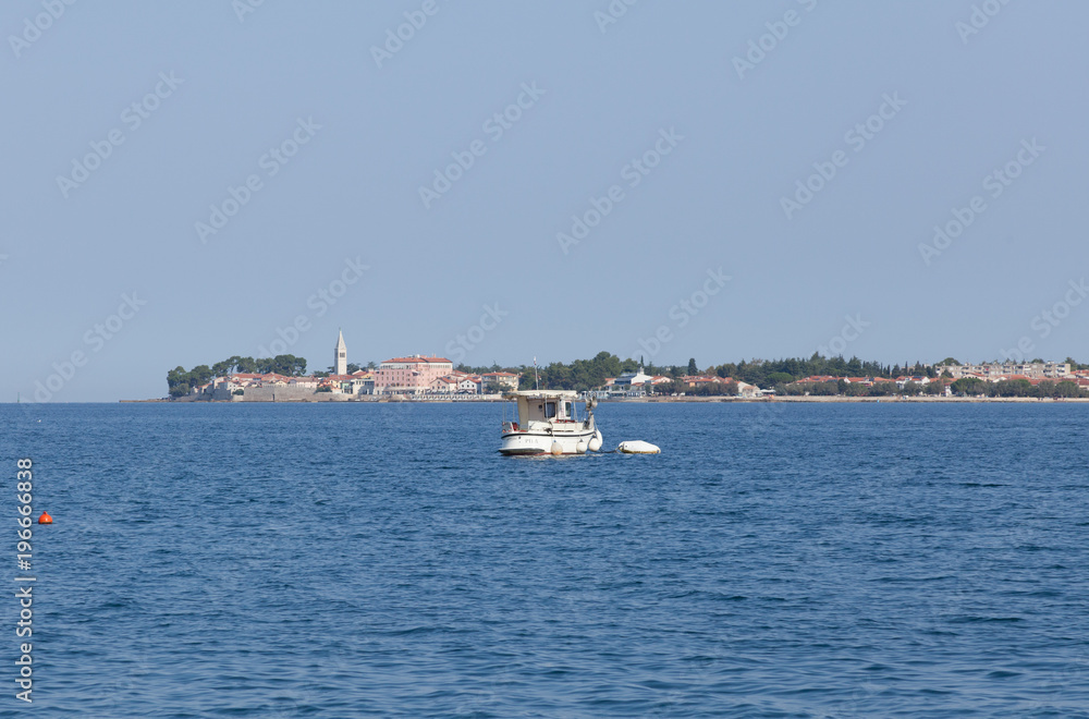 Small boat and city on the sea