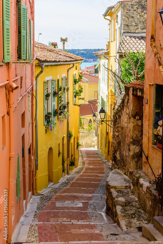 Fototapeta Naklejka Na Ścianę i Meble -  Colorful street with traditional buildings in the old town of Menton, Provence region, France
