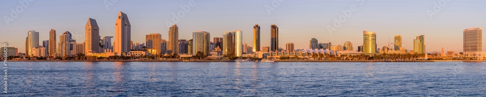 Sunset San Diego Skyline - A panoramic sunset view of waterfront skyline of San Diego Downtown at San Diego Bay, looking from Coronado Peninsula, San Diego, California, USA. Sunset San Diego Skyline - A panoramic sunset view of waterfront skyline of San Diego Downtown at San Diego Bay, looking from Coronado Peninsula, San Diego, California, USA.