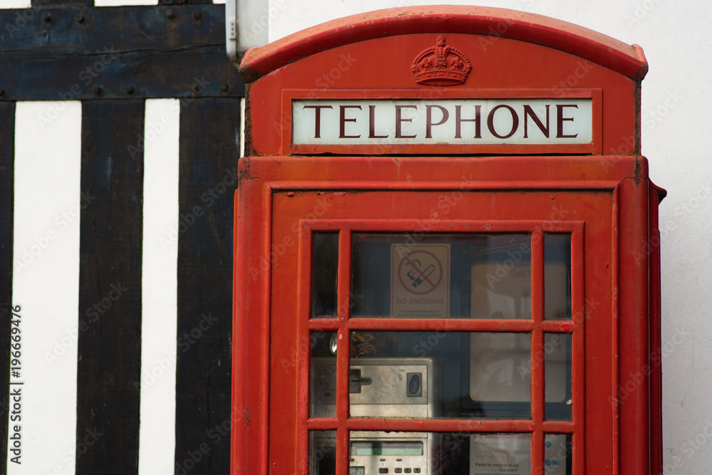 bright red telephone box next to old building with no smoking sign bright red telephone box next to old building with no smoking sign